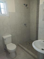 Simple bathroom with tiled walls and pedestal sink for rent La Mitra La Chorrera