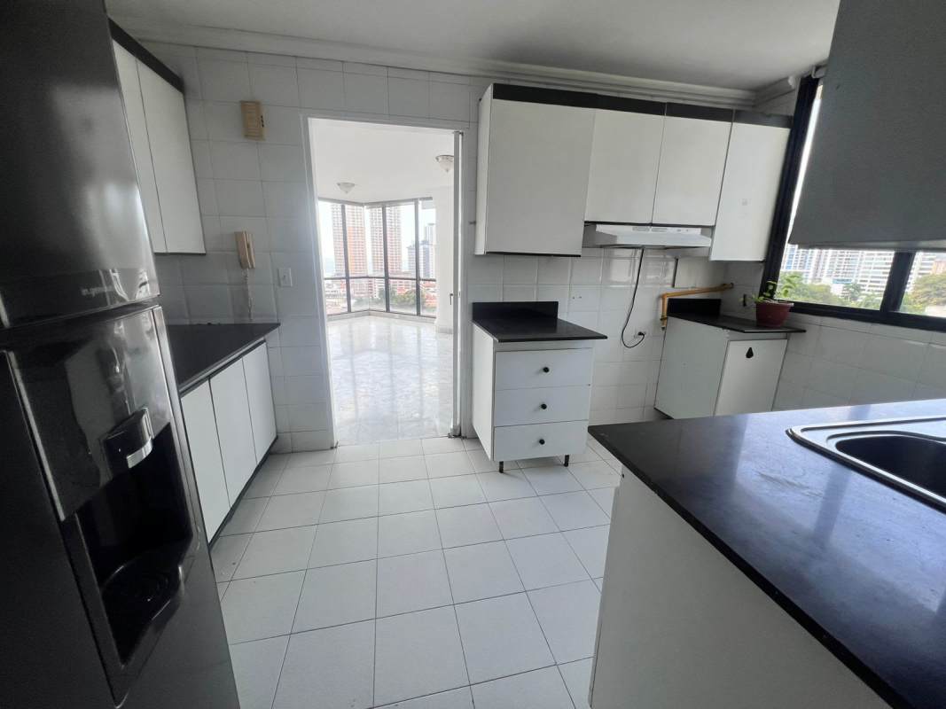 Modern kitchen with granite counters, white cabinetry, and large window in PH Vista Tower Bella Vista Panama