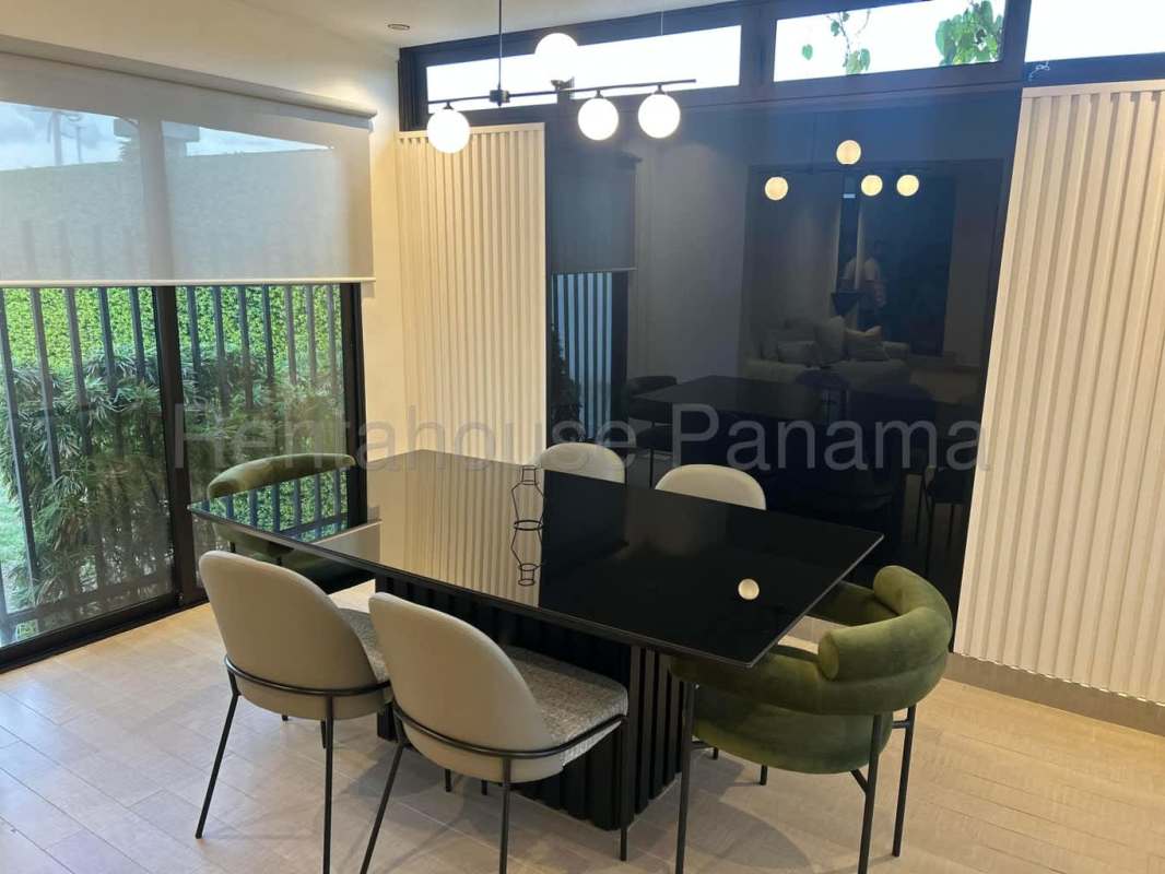 Dining room with large sliding doors and contemporary chandelier in Costa Linda Panama home