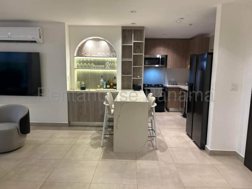 Contemporary kitchen with island breakfast bar next to stylish dining area in Costa Linda Panama