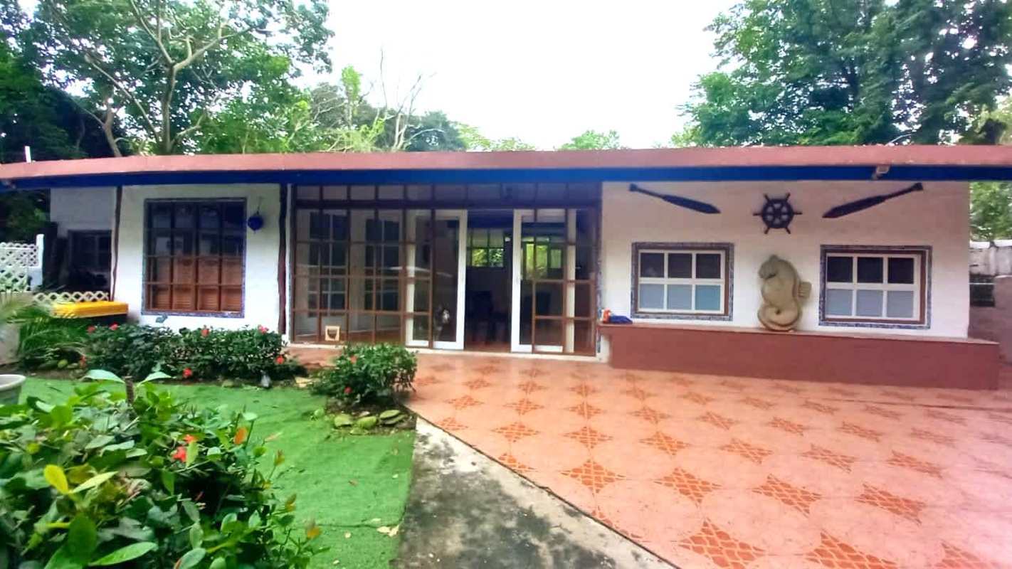 Rustic coastal cabin style exterior with nautical theme and lush garden on Isla Contadora Panama