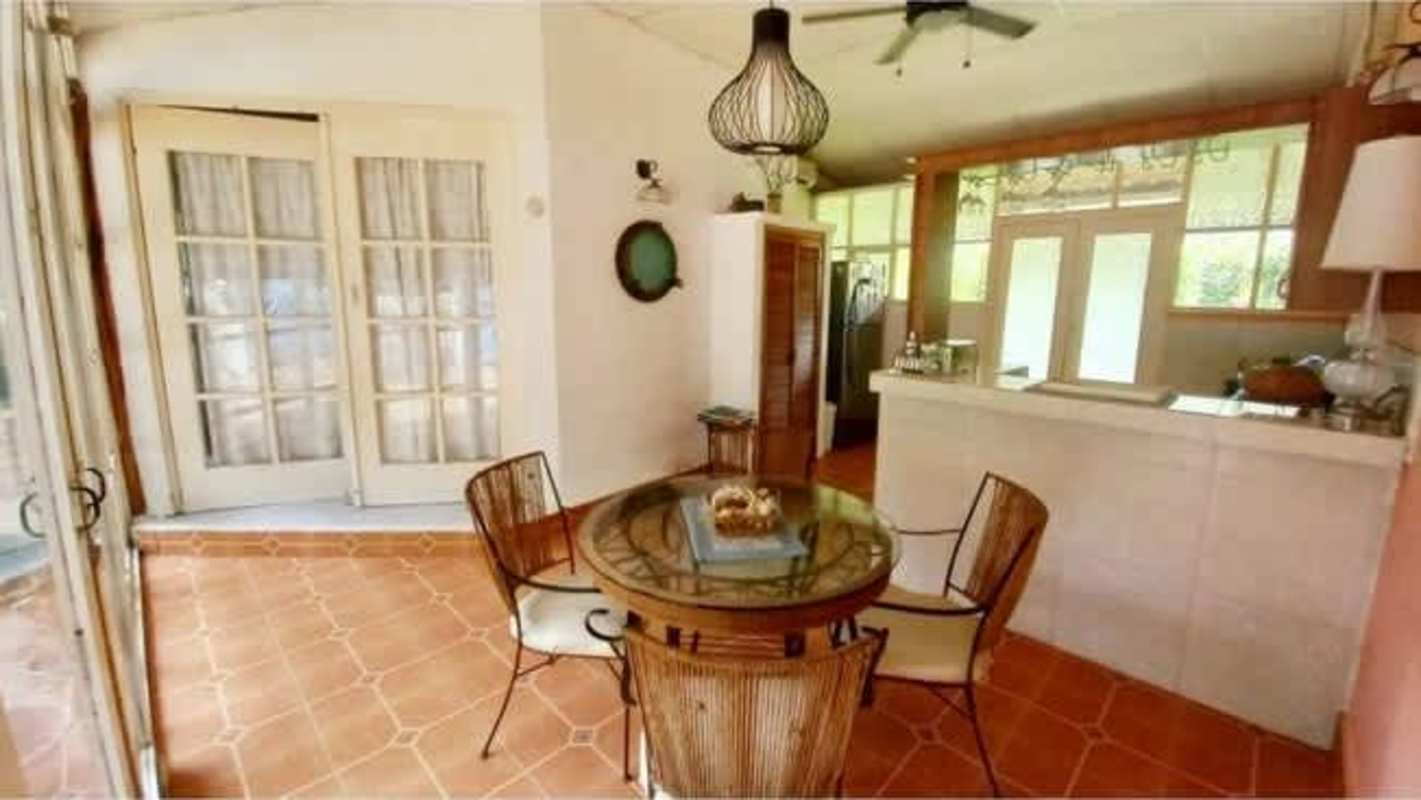 Dining room with terracotta floor adjacent to kitchen Isla Contadora beach house