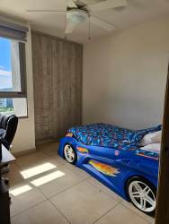 Bedroom for children with car-shaped bed, ceiling fan, large window, wood accent and tile floor