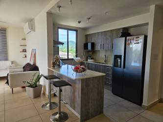 Bathroom with glass enclosed shower, modern vanity, marble finishes in Panama Pacifico apartment