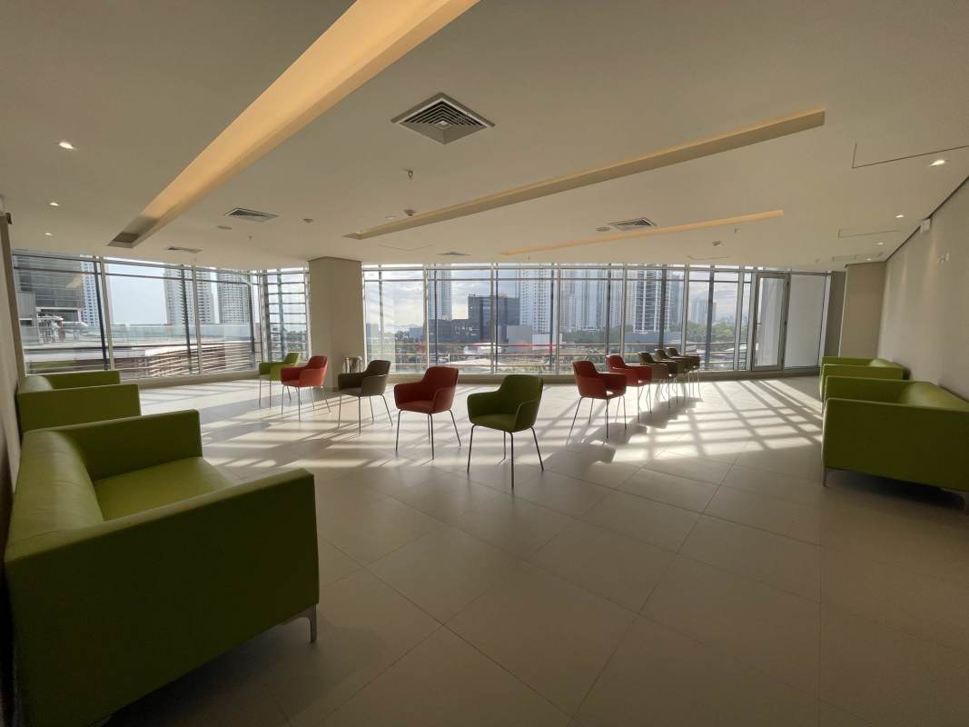 Lounge with large windows, sofas, city skyline views in Torre Arboleda Panama