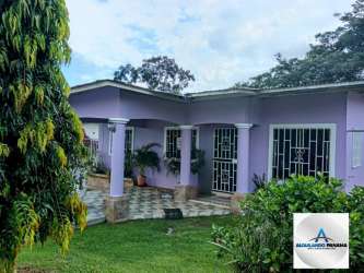 Bright living room with sectional sofa and vivid red curtains at Los Algarrobos house