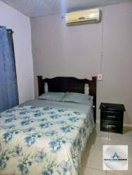 Front view with carport, paved driveway, garden, and gates at Los Algarrobos house Panama