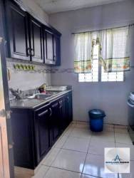 Kitchen with dark cabinets, stainless sink and ceramic floor in Los Algarrobos house