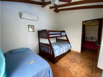 Beach house kitchen with granite counters, wood cabinetry, exposed ceiling beams in Playa Blanca Panama