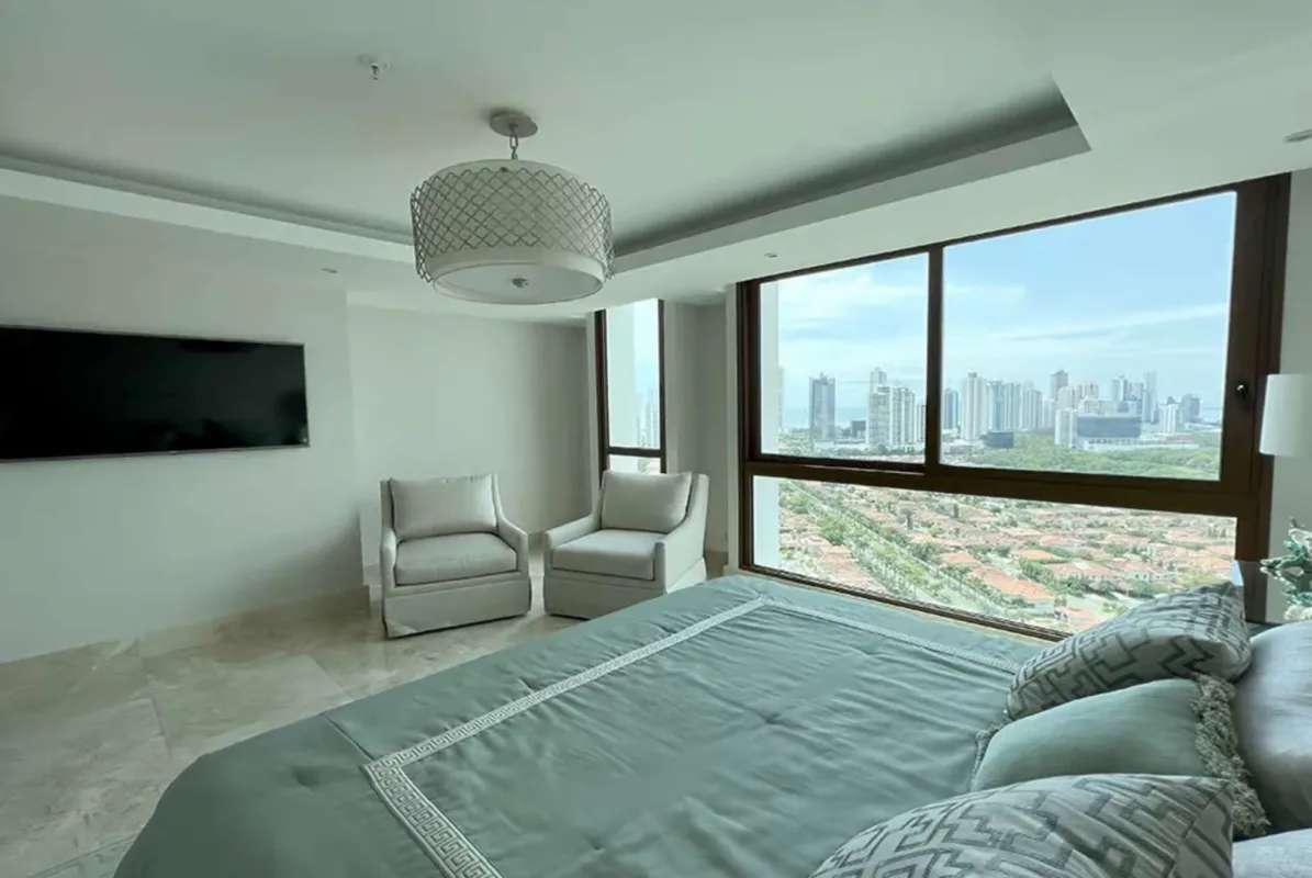 Modern bedroom with large windows overlooking city skyline at PH The Colonial Santa Maria Panama