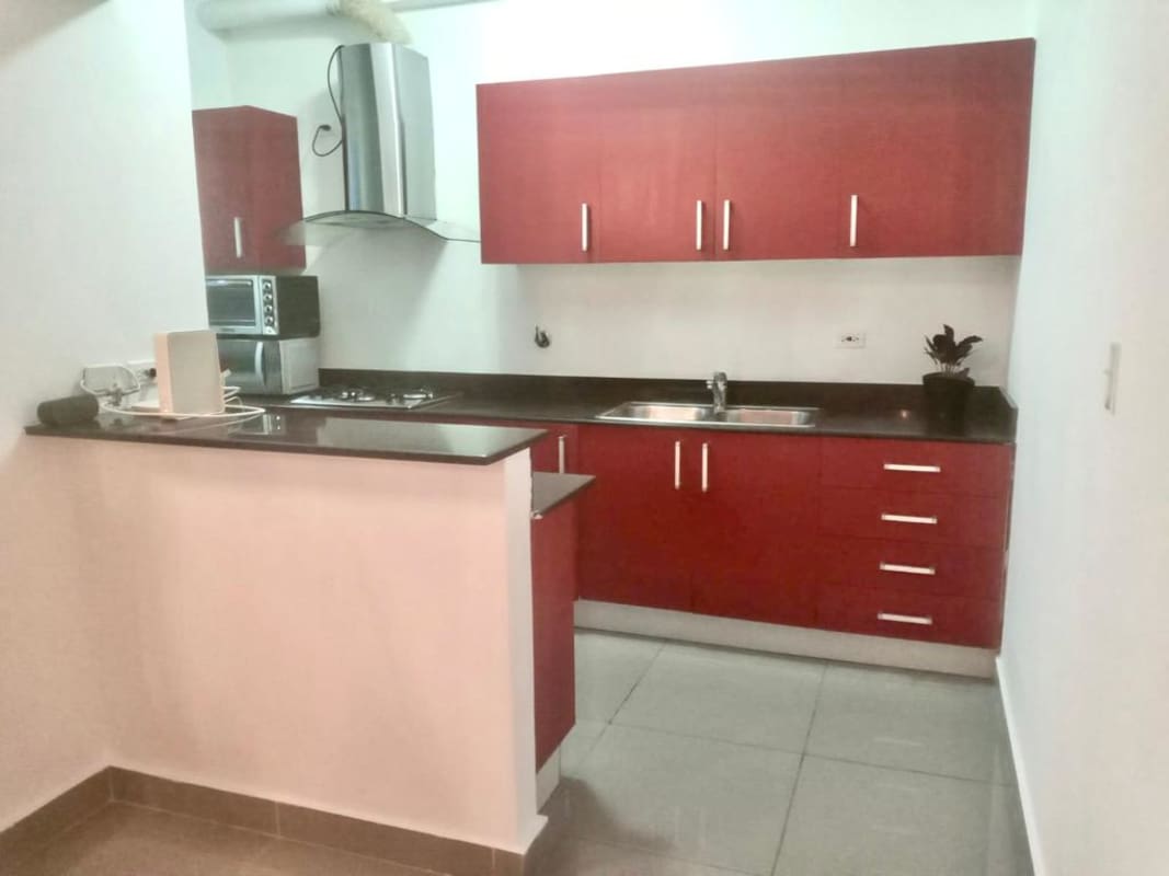 Stylish modern kitchen with granite countertops, red cabinetry and stainless appliances at PH Quartier 74