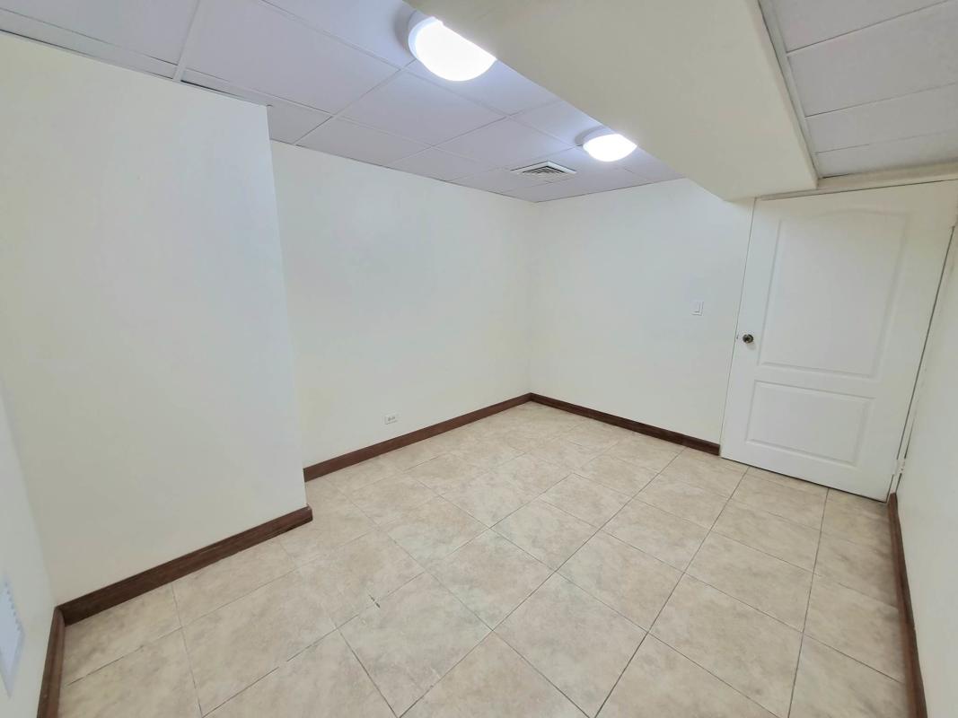 Interior hallway entrance with white spiral staircase and glass doors at Plaza Paitilla Panama City
