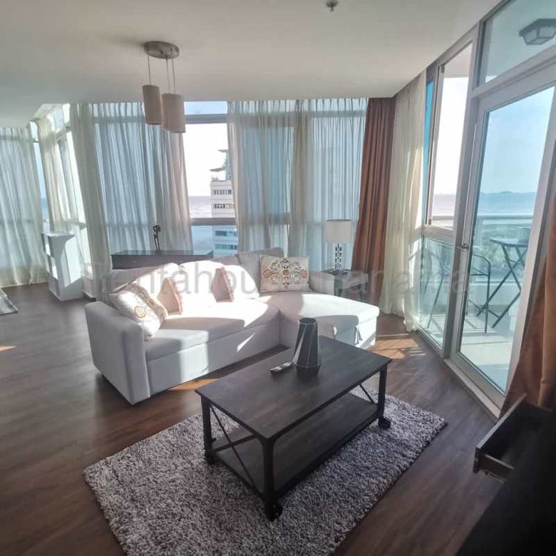 Open living room with panoramic windows, ocean views and balcony access at PH Riverside Panama