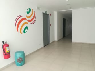 Modern building hallway with art, elevator, stool PH Ocean View Playa Corona