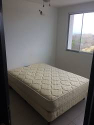 Bright bedroom with window overlooking forest and ocean in PH Ocean View Playa Corona