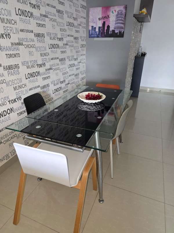 Dining area with glass table, assorted chairs and accent wallpaper in PH Diamond Tower Panama furnished rental