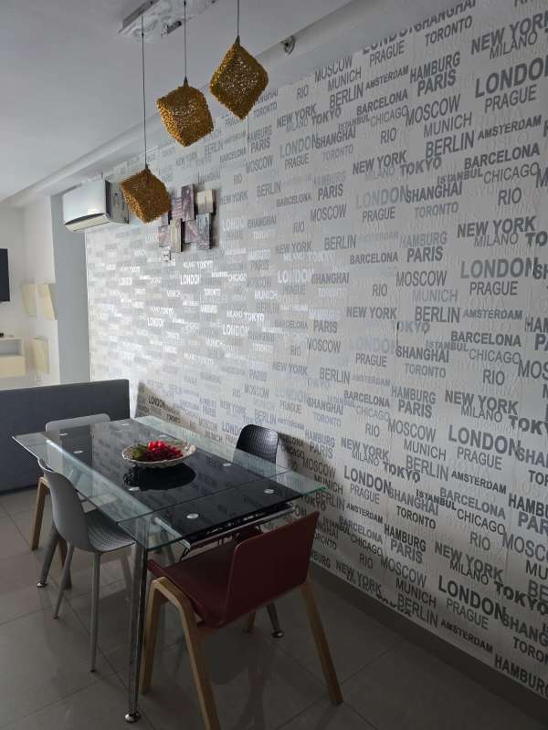 Living room with mounted TV, sofa and decorative wall in PH Diamond Tower San Francisco Panama rental apartment