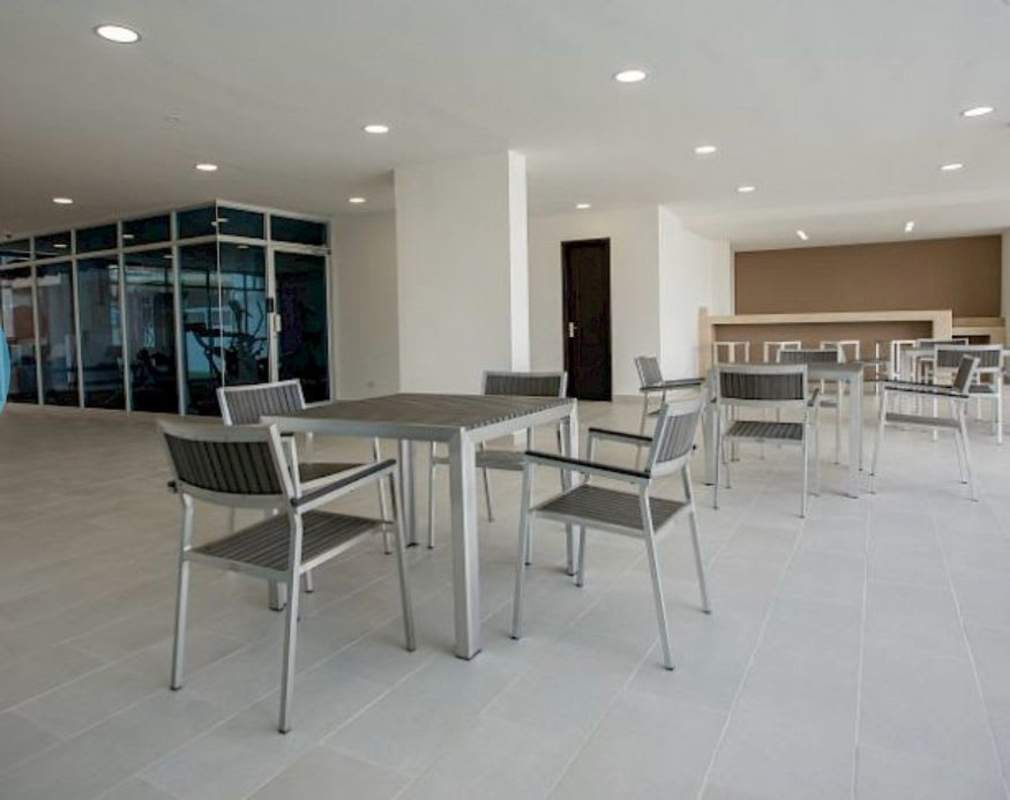 Indoor social lounge with tables and bar counter PH Carrasquilla Park Panama