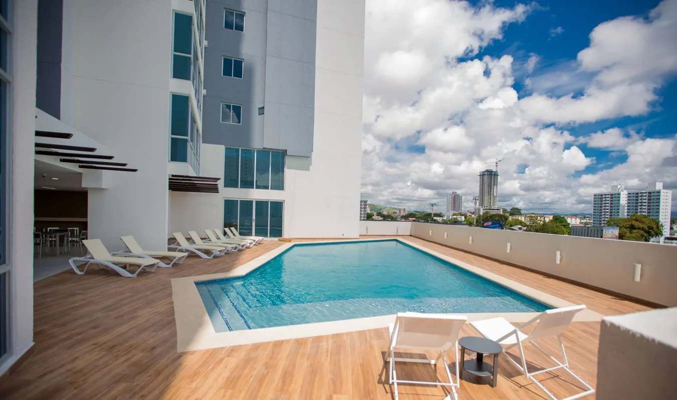 Rooftop swimming pool with lounge chairs overlooking Panama City skyline PH Carrasquilla Park