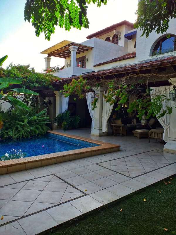 Traditional double-height foyer with curved staircase and elegant decor in luxury home Altos de Golf Panama City
