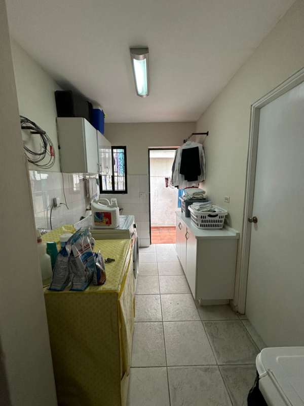 Laundry room with washer area, storage space, backyard access in La Alameda house Panama