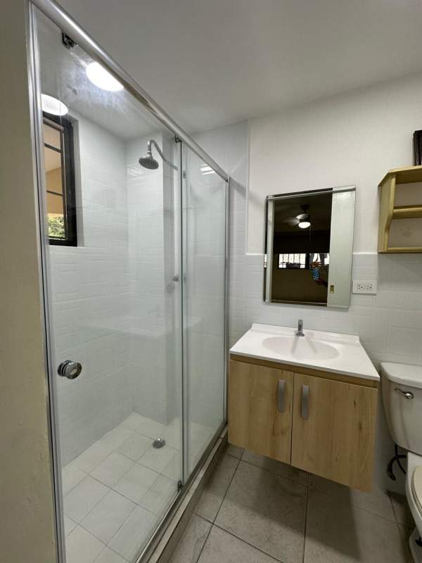 Modern bathroom with glass shower, vanity and tile work in La Alameda home Panama