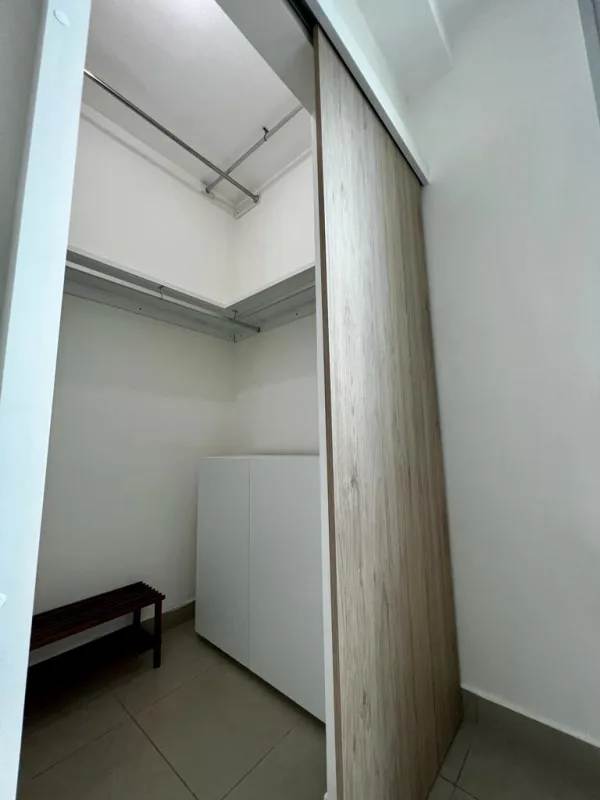 Walk-in closet with shelves, wooden sliding door, organized space at PH Latorraca Panama City