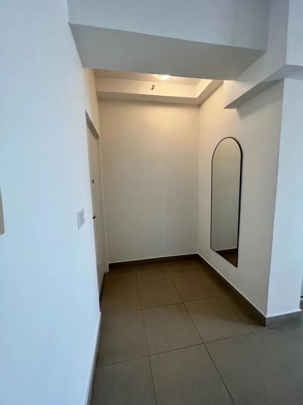 Entry with arched mirror, large tiles, minimalist design in PH Latorraca Panama City