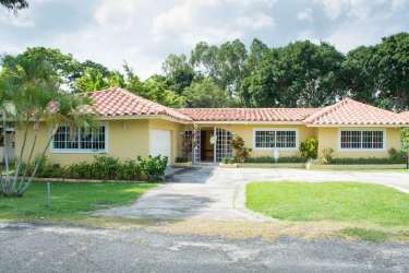 Large fenced backyard with tropical plants at Coronado Golf & Beach Resort home for sale