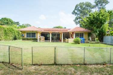 Traditional kitchen with wooden cabinetry and bar seating in golf resort home in Coronado Panama