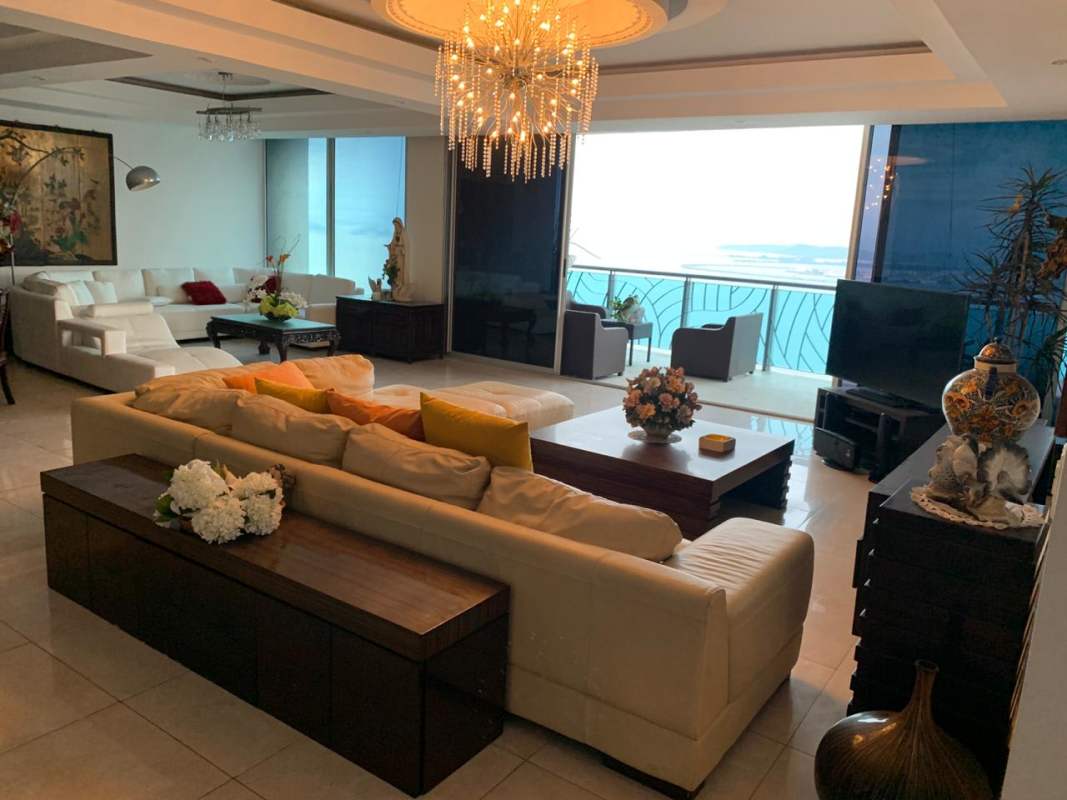 Elegant living area with chandelier, floor-to-ceiling windows ocean views, marble floors in PH Aquamare Punta Pacífica