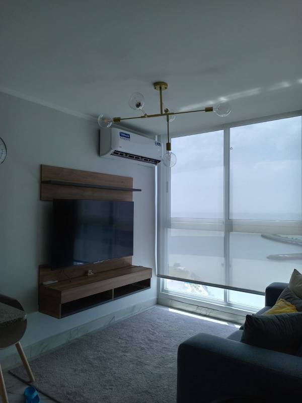 Open concept kitchen with granite surfaces and stainless steel appliances next to furnished living room PH The Sand Panama City