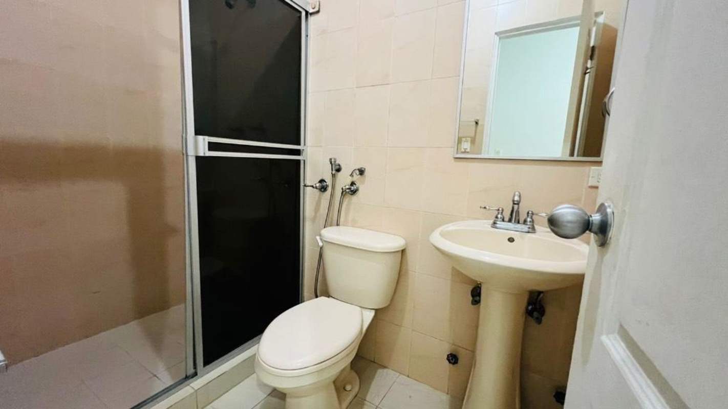 Contemporary bathroom with beige tiles, glass shower, pedestal sink and mirror Edison Park Panama
