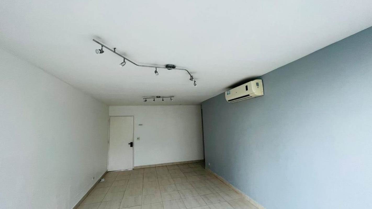 Minimalist living area with ceramic floor, AC unit, track lighting and accent wall Panama City