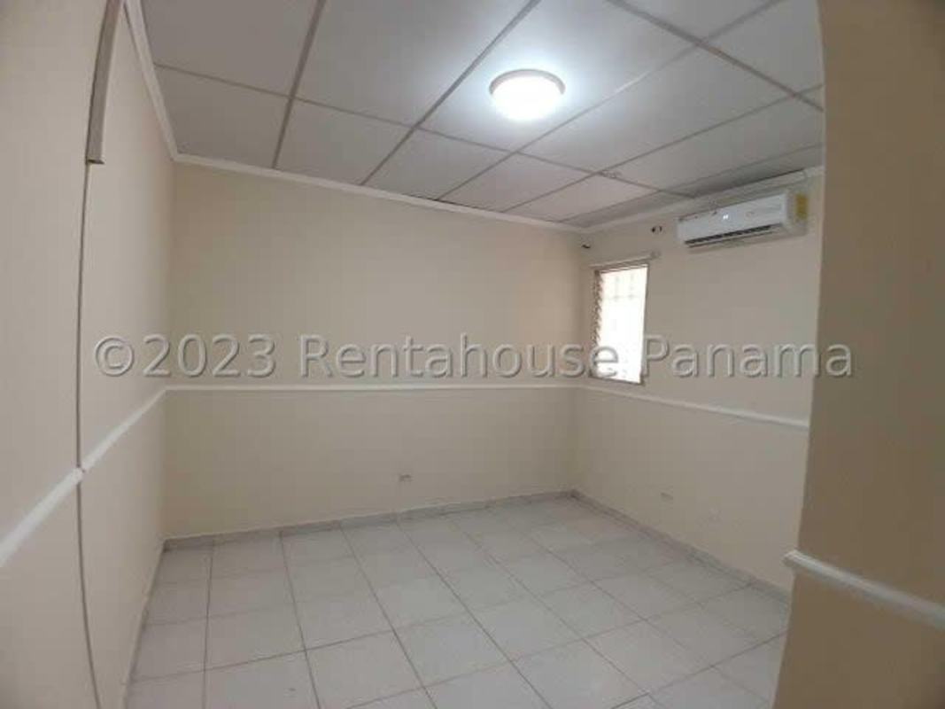 Open backyard patio with soil garden, white fence, yellow wall El Crisol Villa Lucre Panama