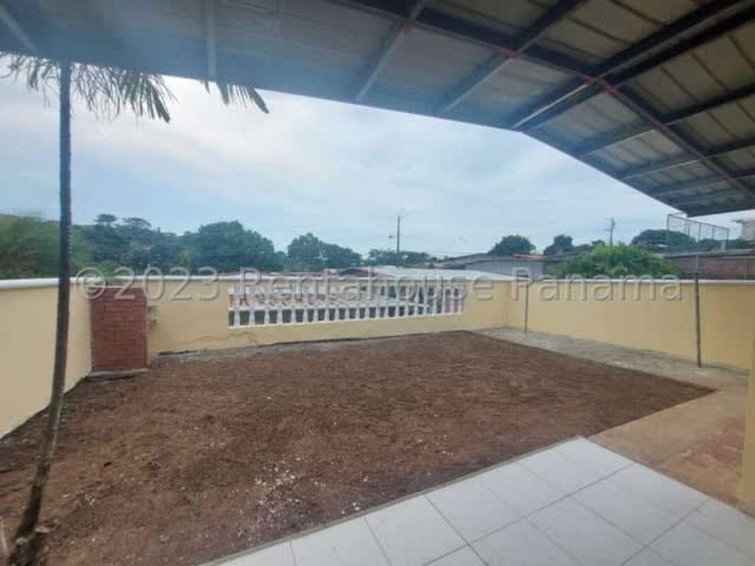 Large backyard patio with partial fencing and covered terrace area at El Crisol Villa Lucre