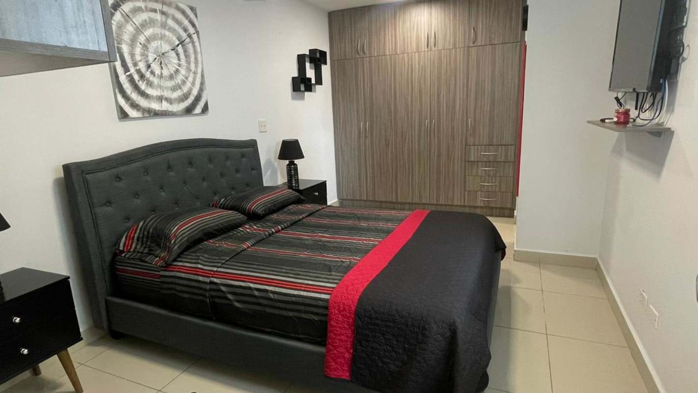 Modern bedroom with bed, built-in wardrobe, TV and decor at PH Red Point Panama