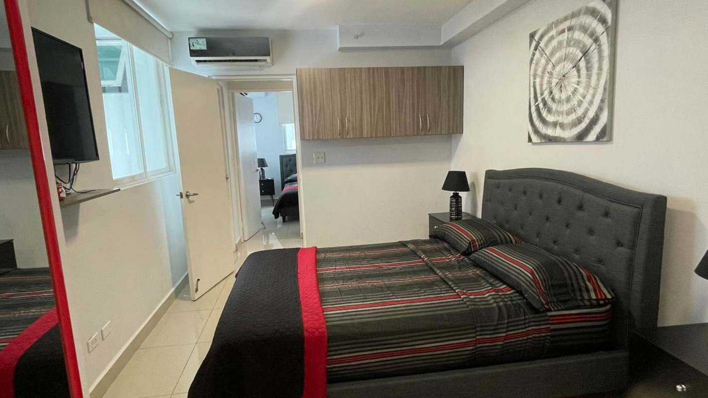 Bedroom with upholstered bed, built-in closet, AC, window with blinds at PH Red Point Panama City