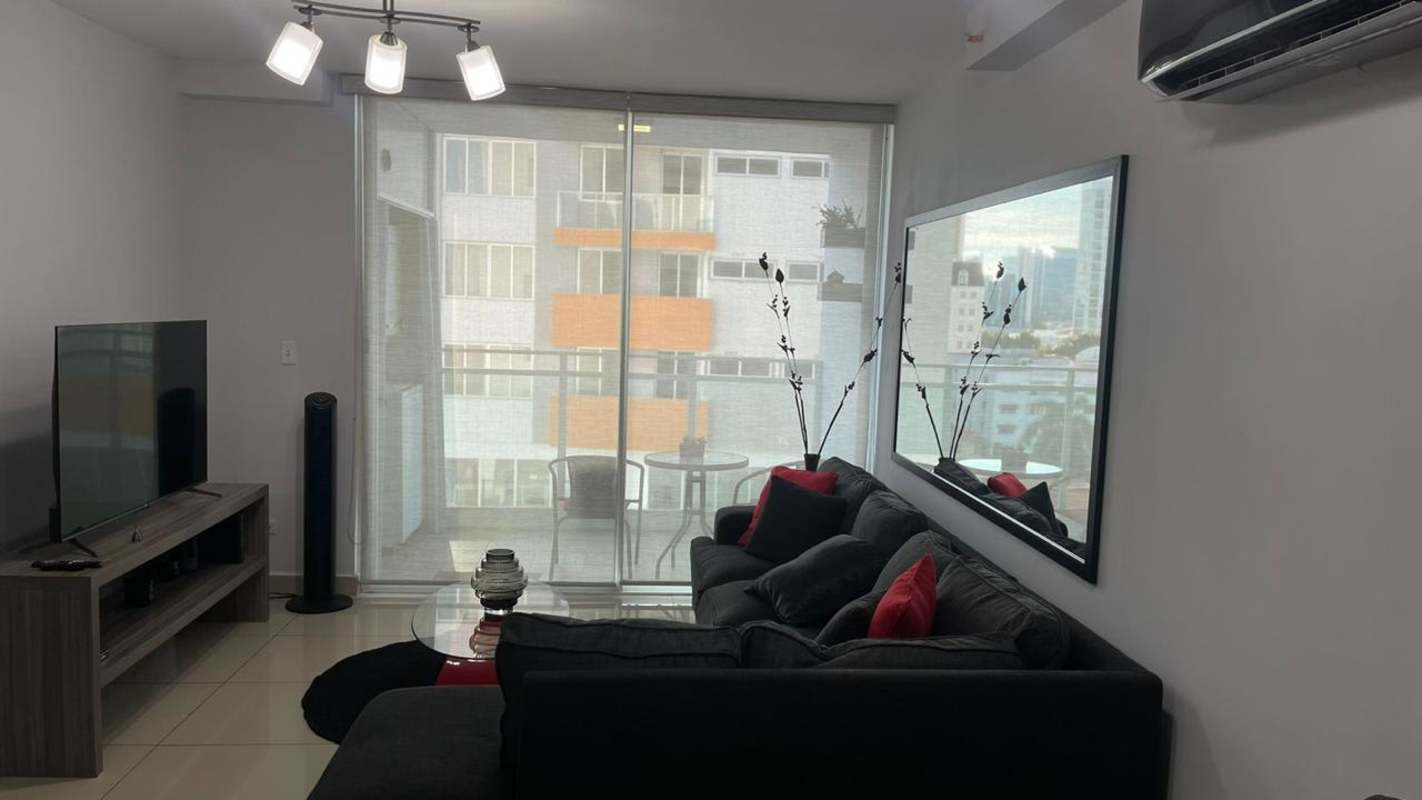 Living room with sofa, TV, large sliding doors to balcony PH Red Point Panama City