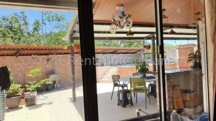 Covered patio with dining area, plants, glass door in La Chorrera Panama