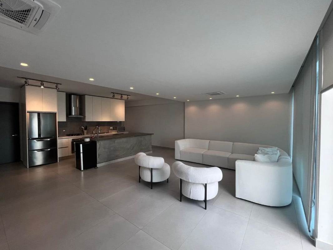 Spacious open plan living area with modern kitchen and floor-to-ceiling windows at PH BICSA Tower Panama