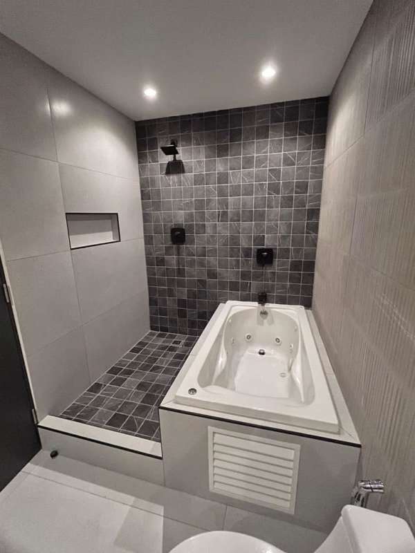 Luxury bathroom with walk-in shower and bathtub, tiled in gray at PH BICSA Tower Panama City