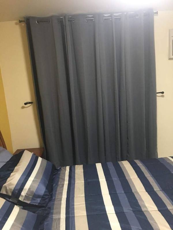 Bedroom with striped bedding, curtain, simple decor PH Carrasquilla Plaza Panama