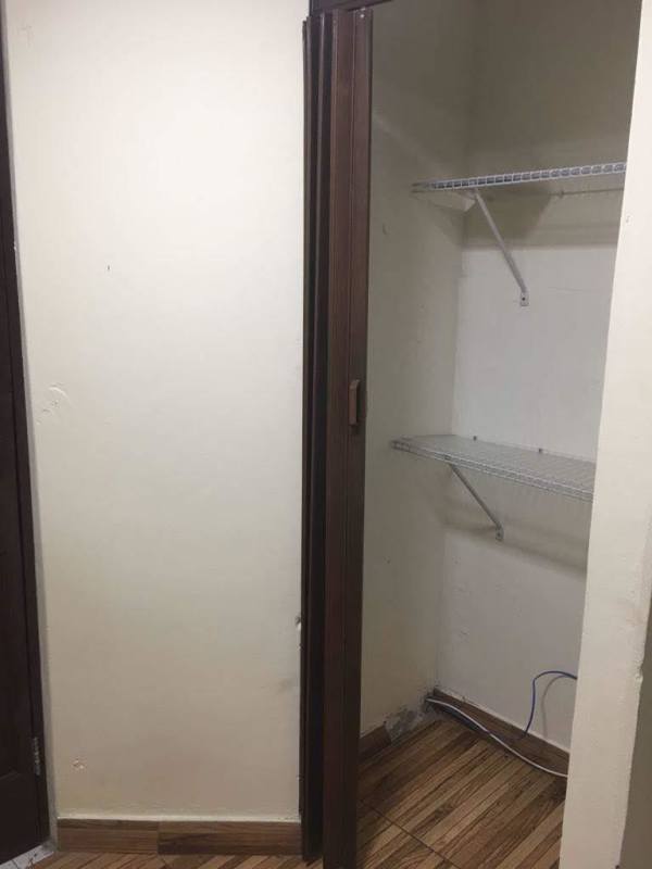 Living room with blackout curtains, wooden door, plaid sofa PH Carrasquilla Plaza Panama City