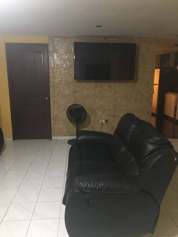 Furnished living room with flat-screen TV, recliner sofa, textured wall, tiled floor PH Carrasquilla Plaza Panama