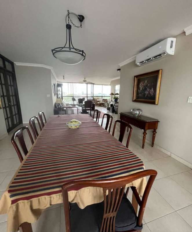 Elegant dining area with striped tablecloth and panoramic city ocean view in PH Riviera del Mar Panama