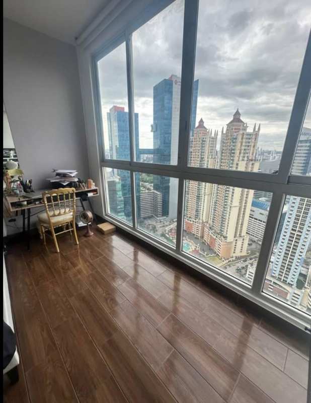 Compact workspace corner with floor-to-ceiling windows overlooking Panama skyline at PH Pacific Point