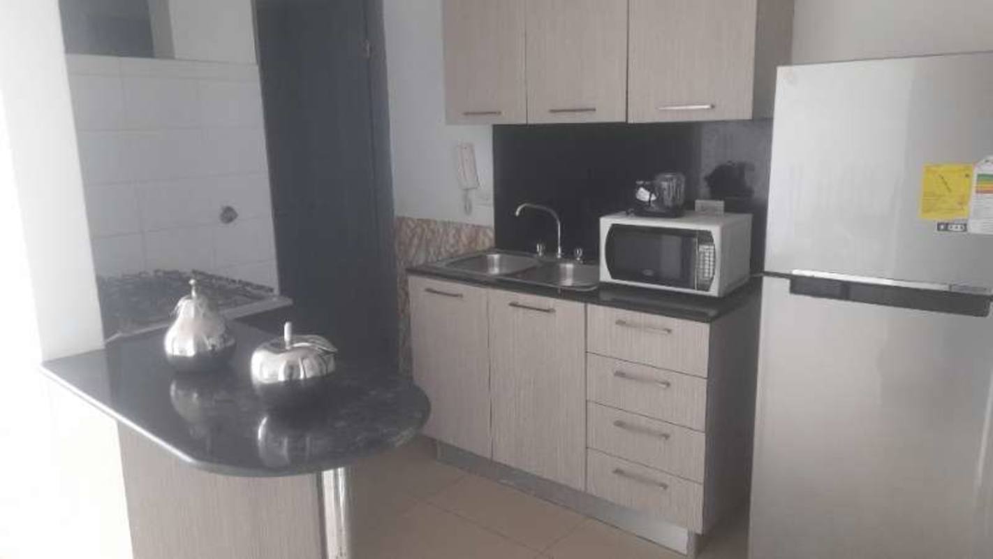 Compact kitchen with granite countertop, dual sink, light wood cabinets in PH Green Park Condado del Rey