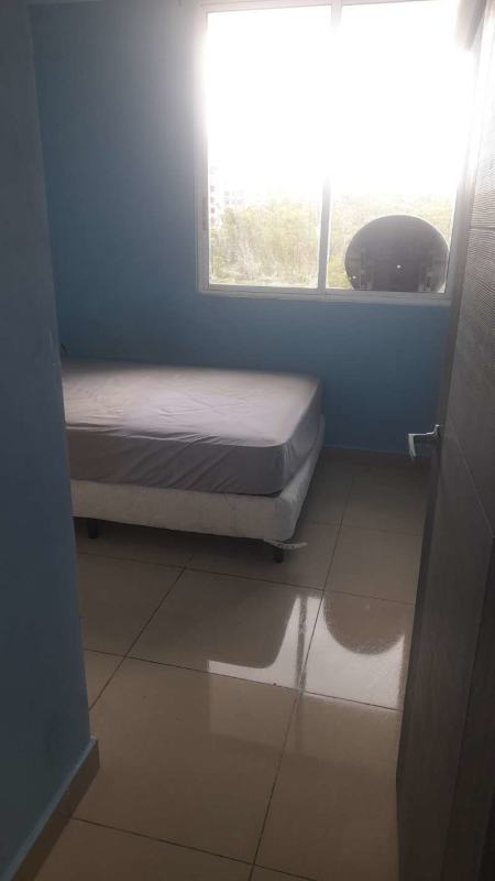 Bedroom with blue accent wall, large window with urban view, tiled floor in PH Green Park Condado del Rey Panama