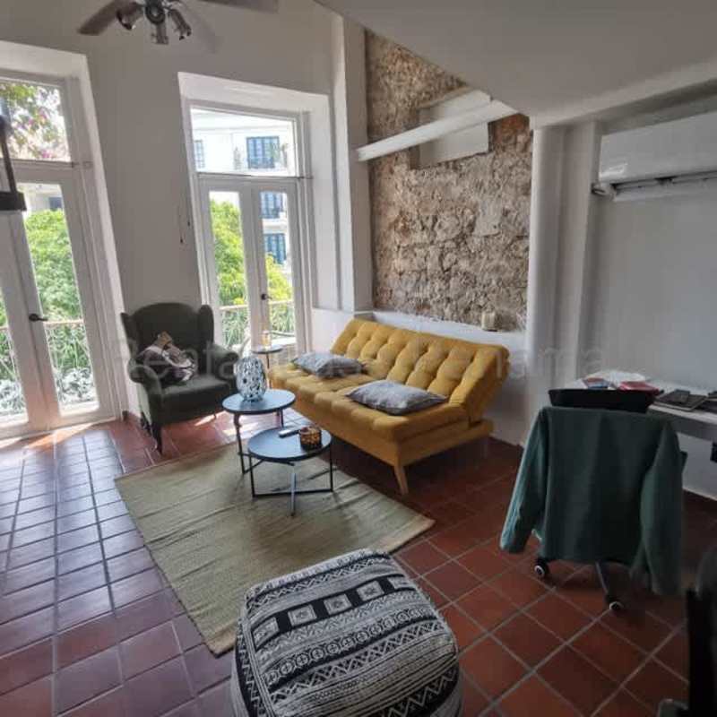 Living room with brick wall, yellow sofa, balcony views Casco Viejo Panama